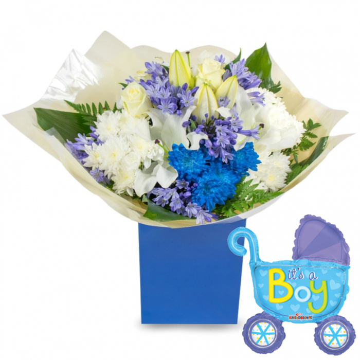 A joyful, carefully balanced baby-gift composition sits against a clean white backdrop: a compact, round bouquet of white roses, white lilies with soft yellow stamens, and plush white chrysanthemums rises from a rich royal blue box, the deep hue anchoring the arrangement. Intense electric-blue chrysanthemums form vivid accents that catch the eye and reinforce the celebratory 'boy' theme, while soft clusters of lavender-blue, hyacinth-resembling flowers weave between the larger blooms to create delicate textural contrast. Sprays of verdant foliage-broad, matte leaves and feathery fern tips-nestle around the blooms, lending a natural, garden-fresh quality. The bouquet's base is wrapped in a crinkled, cream-coloured tissue that softens the visual transition to the box, suggesting the tactile pleasure of unwrapping a present. Floating to the right is a light-blue foil pram-shaped balloon, detailed with darker-blue canopy and wheel accents, dotted trims, and small heart motifs; across its side the playful inscription It's a Boy appears in cheerful yellow and lime-green lettering. Soft daylight picks out the satin sheen on petals and the metallic glint of the balloon, while the scent profile leans clean and green with sweet hyacinth notes and the crispness of fresh roses. Ideal for a hospital bedside or a welcoming-home visit, this arrangement evokes quiet celebration - a gift that would feel perfectly at home being delivered across Grove Park or dropped off near Downham, made to comfort and delight new parents.