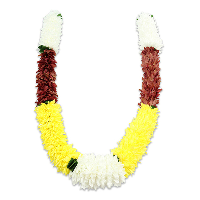 A vibrant, U-shaped floral mala is presented against a crisp white background, the slight shadow beneath it giving a sense of weight and form. From each upper tip a compact band of creamy white, chrysanthemum-like fabric flowers forms a soft, cylindrical start, their countless fine petals arranged to create a plush, clouded texture. Directly below these white segments sits a dense swath of maroon or reddish-brown blooms; their smaller, tightly clustered petals add a rich, grounding mid-tone that contrasts with the light above. The longest portion of the garland is a generous, sunshine-yellow run of fluffy, marigold-resembling artificial flowers that shapes the U's broad curve and draws the eye downwards. Where the yellow arms meet at the base, a substantial central cluster of pure white chrysanthemum-style blooms provides a bright focal point, and small dark green leaf accents are placed at several transition points - notably between yellow and white - to break the color blocks with a natural touch. The construction is clearly artisan-made: thousands of fabric petals layered and stitched to mimic living flowers while offering resilience for repeated ceremonial use. In Grove Park and nearby community halls, this combination of white, yellow, and maroon is chosen for its cultural resonance - purity, prosperity, devotion - making the garland appropriate for Hindu pooja, temple offerings, wedding entrances, and festival decorations. The overall impression is traditional and celebratory, a durable yet delicate-looking piece that carries ceremonial meaning and local craftsmanship in every stitch.