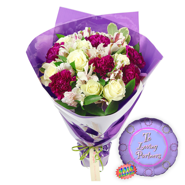 Against a simple white studio-style background, a vibrant bouquet and matching balloon are presented as an ideal graduation gift from a local Grove Park florist. The bouquet itself is full and uplifting, built around velvety creamy white roses that are just beginning to open, their petals spiralling outward in carefully layered whorls. These romantic blooms are contrasted with deep fuchsia and magenta flowers, probably carnations or chrysanthemums, whose densely ruffled petals create rich, textured spheres of colour that instantly draw the eye. Soft white filler flowers, akin to baby's breath, weave gently between the major blooms, giving the arrangement a light, airy dimension. Framing everything is an abundance of fresh green foliage, ranging from slender leaves to broader, glossy greens that evoke the natural calm of Grove Park's tree-lined streets and nearby Dukes Meadows. 

The wrapping enhances the bouquet's festive character. A sheet of intense purple paper encloses the stems and blooms, folded and fanned into structured shapes that rise behind the flowers like a backdrop. The paper narrows at the bottom, where it is banded with a green and white ribbon that may bear a subtle design, echoing school ties or house colours, and tied securely to keep the stems hidden and protected. To the lower right of the bouquet sits a round purple Mylar balloon, its shiny surface catching points of reflected light. Across the centre, in an elegant white script that stands out clearly against the purple, the words To a Loving Graduate express admiration and affection. Just beside the balloon, a small oval sticker or tag in green and white suggests a brand mark or quality guarantee, reinforcing the sense of a carefully curated gift set. This composition perfectly represents a joyful, thoughtful way to honour exam results, graduation ceremonies, or milestone achievements for students living in or around Grove Park.