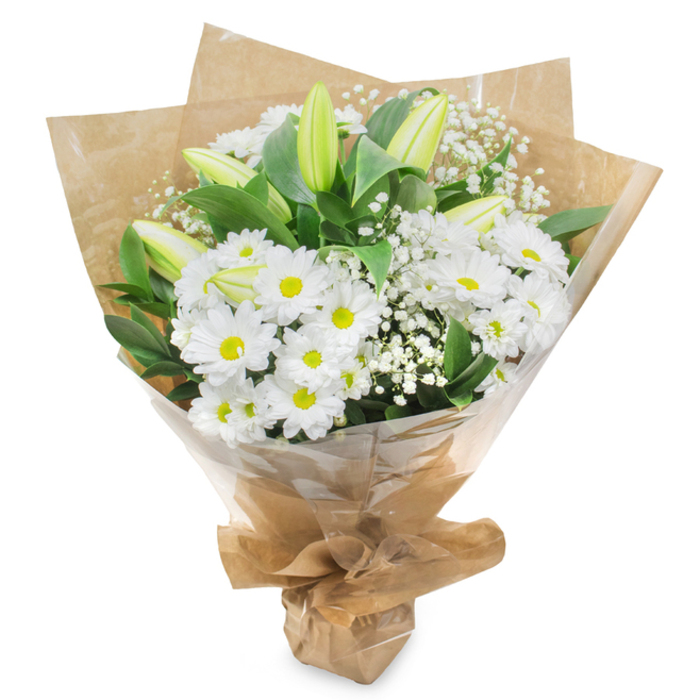 A softly lit white and green bouquet stands alone against a clean white background, its classic shape and textures clearly defined, as if displayed in the window of a Grove Park Florist shop along a quiet, leafy street. At the centre, clusters of white daisy-like chrysanthemums dominate the arrangement, each flower boasting layer upon layer of slender petals encircling a fresh yellow-green core. These centres lend a touch of warmth and life to the otherwise serene palette, like small points of light. The chrysanthemums are grouped tightly, forming a full, rounded body that offers a reassuring sense of abundance and calm. Rising out from within this cushion of daisies, several elegant lily buds stand tall. Their smooth, tapered forms are enveloped in pale green that gradually fades into cream or near-white at the tips, with no petals yet unfurled. Their presence suggests the gentle passage of time and the unfolding of memories, much like an unhurried walk through nearby Chiswick and Grove Park gardens. Woven throughout the bouquet, fine sprays of white baby's breath bring a cloud-like softness, their numerous tiny flowers scattered along thin, flexible stems. Around the edges, rich, dark green foliage curves gracefully, creating a natural frame that sets off the white blossoms, the leaves catching slight reflections of light and adding depth. The stems are snugly wrapped in rustic brown kraft paper that bears natural creases and folds, lending a tactile, earthy quality. Over this, a clear layer of cellophane hugs the form of the bouquet, providing a subtle gloss while keeping the flowers fresh for local delivery. The base is neatly gathered and tied, forming a simple, elegant cone that is easy to carry. The bouquet exudes a mood of purity, gentle sympathy, and quiet hope, ideal for funeral tributes, condolence gestures, or placing as a thoughtful arrangement in a peaceful Grove Park home.
