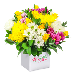 A richly textured, rounded bouquet of fresh flowers rises generously from a minimalist white square box, showcased against a spotless white background that lets each hue and shape stand out. At its heart, sun-bright yellow chrysanthemums and compact yellow spray roses cluster together, their ruffled petals forming a plush, almost cloudlike centre that feels both joyful and comforting. Between these golden tones, there are crisp white blooms: small, daisy-like flowers with green button centres and fuller white chrysanthemums with finely cut petals that add softness and airy volume. Threading through this sea of yellow and white, deep fuchsia and magenta chrysanthemums provide artful splashes of richer colour, some with a hint of lighter pink shading at the tips, giving the bouquet depth and a hint of playful sophistication. Encircling the flowers is a collar of glossy, dark green foliage that peeks between the heads and frames the entire design, making the bright colours appear even more vivid. The arrangement sits snugly in a cube-shaped white gift box with clean lines and a smooth finish; on the front, a small red rose graphic and gently curved green and red lettering hint at a trusted local flower shop rather than a generic gift supplier. The composition feels both contemporary and welcoming, the kind of floral box you might send from Grove Park to brighten a flat near the station, a family home close to Chiswick House, or an office along Burlington Lane. The overall impression is of a well-balanced, uplifting bouquet suited to birthdays, thank-you messages, and everyday moments that call for a burst of colour and freshness.