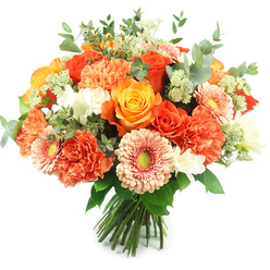 Bathed in bright, natural light against a crisp white background, this hand-tied bouquet feels like a pocket of summer brought into a Grove Park sitting room. The design is densely arranged and rounded, crafted to showcase a warm, uplifting palette: deeply coloured orange roses alongside golden-yellow roses whose spiralling petals open like small suns. Intermingled coral and peach carnations offer a soft, ruffled counterpoint, their multi-layered petals creating a plush, tactile surface. Peach-toned gerbera daisies lend a playful openness with flat radiating petals and vivid green centers that echo the fresh foliage. Tiny white filler blooms-resembling freesia or spray flowers-dot the composition with clean, bright accents, while wisps of pale green Astrantia-like filler provide feathery, almost lace-like texture. The ubiquitous silvery eucalyptus leaves, with their rounded, muted green shapes and cool fragrance, are woven through the bouquet, providing both structure and a calming visual backdrop. The gathered stems are neatly tied at the base, a practical finish that signals fresh, florist-tied quality suitable for vase display or delivery. As a local touch, this arrangement would be a flattering choice for birthdays or thank-you bouquets delivered within Grove Park, just a short run from Grove Park station and the high street. Prepared with the care you'd expect from Grove Park Florist, it conveys warmth, celebration, and a reassuringly fresh scent that fills a room without overpowering conversation.