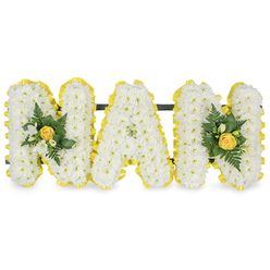 Soft, cloud-like chrysanthemums form the body of this lovingly arranged sympathy piece, their pristine white sprays gathered so closely they read as a single, velvety surface that invites the hand to linger on texture. At either end the composition is brightened by two mellow, furled yellow roses, their petals holding a delicate, sun-warmed glow that suggests fond memories and gentle laughter. Interspersed through these focal points are tiny shoots of fresh, bright-green foliage and bead-like leaves that add a lively, springlike lift; delicate white freesia or similar small buds nestle nearby, lending a faint citrus-floral scent when the piece is approached. The craft is quietly meticulous: each chrysanthemum head has been set to preserve the letter-shape and overall balance, the soft white offset by measured pops of yellow that never overpower. Presented against a clean white background and photographed in soft natural or studio light, the tonal interplay reads as comforting rather than stark, evoking afternoon light in a family home or the calm of a community chapel. This design is written with the intimacy of a tribute for a grandmother, a floral language that honours dignity while inviting warm remembrance. As a florist familiar with Grove Park and neighbouring Downham, I imagine delivering this calm, thoughtful piece to a local wake on Baring Road or leaving it at a family gathering close to the nature reserve, where its gentle scent and soft colours can help carry memory into the days that follow.