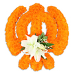 A reverent, hand-crafted floral Khanda floats against a clean white backdrop, every curve and edge formed from hundreds of tightly packed bright orange marigold blossoms. The marigolds' compact, velvety heads create a rich, sunlit texture that reads like woven saffron cloth; light catches the tiniest ruffled petals and throws soft highlights across the circular chakkar and the twin kirpans, while the upright double-edged khanda at the centre reads with stately clarity. Nestled precisely where the swords intersect is a small but striking cluster of pristine white lilies - at least two fully open blooms with gently cupped petals, pale green throats and yellow-green stamens, surrounded by a few pointed buds about to unfurl. Lush green foliage, reminiscent of salal leaves, frames the lilies and edges the orange field, and breathy sprays of tiny white gypsophila lift the composition with delicate lightness. The whole piece sits just off the surface, a subtle drop shadow giving the impression of a freestanding tribute or ceremonial display; the arrangement feels three-dimensional and tactile, as if you could brush your fingertips across the dense marigold carpet. There's a warmth to the orange that suggests celebration and devotion, balanced by the quiet, cool perfume of the lilies - a sensory contrast that reads both joyful and respectful. This floral Khanda is suited to sacred observance, Vaisakhi processions, Gurpurab decorations, or a private offering in a Gurdwara, and its craftsmanship reflects the care of an experienced local florist who understands the ceremonial language of flowers in Grove Park and the surrounding Lewisham neighbourhoods.