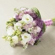 A lavish hand-tied floral bouquet crafted by local florists for Grove Park celebrations, featuring lush white Lisianthus blossoms, delicate lavender stock and gleaming green foliage. The arrangement bursts with elegance, its rounded silhouette sculpted by artfully placed blooms and unopened buds that evoke a sense of hope and new life. Soft petals, intricate ruffles, and slender leaves intertwine, all neatly gathered together and wrapped in a pale pink ribbon, subtly accented with dainty pearls for a hint of luxury. Rested on a neutral, textured background reminiscent of sunlit spaces in Grove Park homes, the bouquet's pastel hues and soft sheen come alive in the gentle light. This romantic design embodies the spirit of Grove Park weddings-modern yet timeless, effortlessly beautiful, and tailored for unforgettable occasions in local venues and gardens. Trust Grove Park Florist to deliver this poetic arrangement, ensuring every petal arrives fresh and full of meaning within the neighbourhood and its welcoming surroundings.