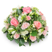 A soft, dome-shaped sympathy arrangement composed of blush-pink roses and pure white freesia sits against a clean white backdrop, every petal and leaf rendered with gentle clarity. The composition is compact and cushion-like, the larger pink roses opening into velvet spirals while smaller spray roses thread delicate, paler pink notes through the heart of the piece. White freesia punctuates the bouquet with upright clusters of bell-shaped blooms; some are fully open, revealing pale yellow stamens, while others remain tightly closed, a promise of quiet unfolding. Deep, glossy green foliage forms a supportive cloak around the flowers - broad, solid leaves that ground the palette - while variegated margined leaves, cream-edged and lively, catch the light and provide a soft, shimmering contrast. No stems are visible; the arrangement's dense, formal construction emphasizes continuity and calm, its silhouette perfectly rounded and balanced. Natural, soft light skims across petal textures, suggesting a faint, fresh scent of roses and the crisp, green note of freesia. As a floral designer who often prepares tributes for moments of reflection in Grove Park and the surrounding neighbourhoods, I imagine this piece placed beside a service or on a family mantle, offering a quietly consoling presence. The colour story - tender pink balanced with pristine white and rich greenery - signals sympathy, warmth, and remembrance, yet retains an elegant restraint suitable for a memorial or a gentle celebration of life. Thoughtfully arranged and long-lasting in form, this bouquet lends comfort without excess, its craftsmanship speaking to careful hands and steady attention to detail.